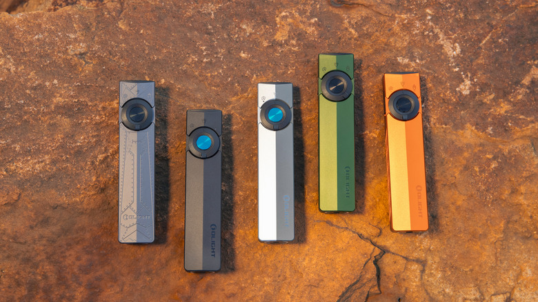 Five colors of Olight ArkPro flashlights on a red rock