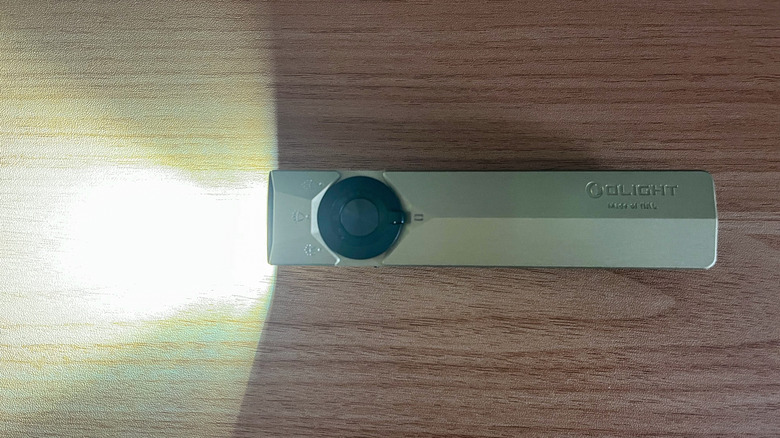 Olight ArkPro Ultra flashlight illuminated on table