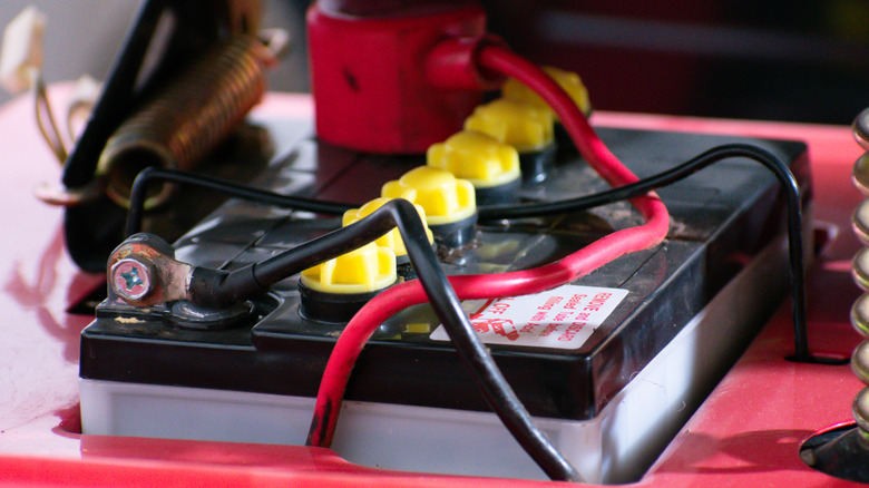 A closeup of a battery inside a riding mower