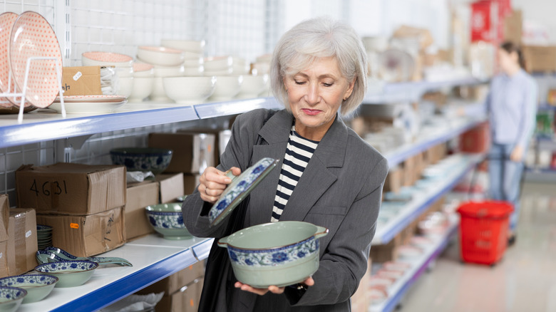 A woman holding a pot at the thrift store