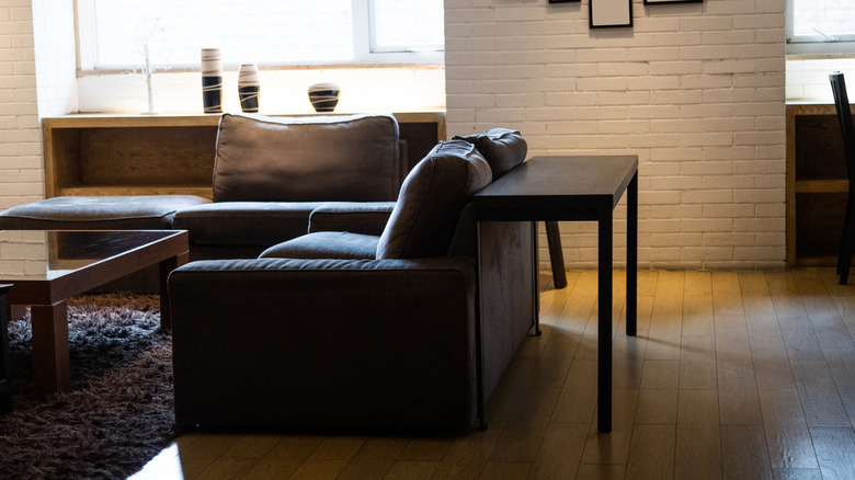Library table creating space behind sofa