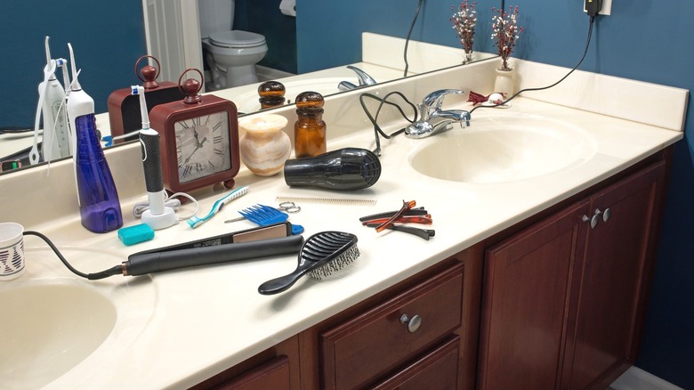 Bathroom counter cluttered with hair care items