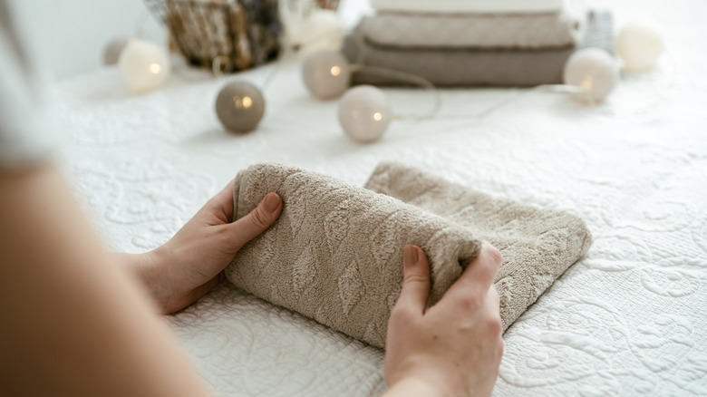 A person neatly folding a small towel