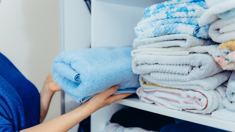 Towels piled up in a linen closet.
