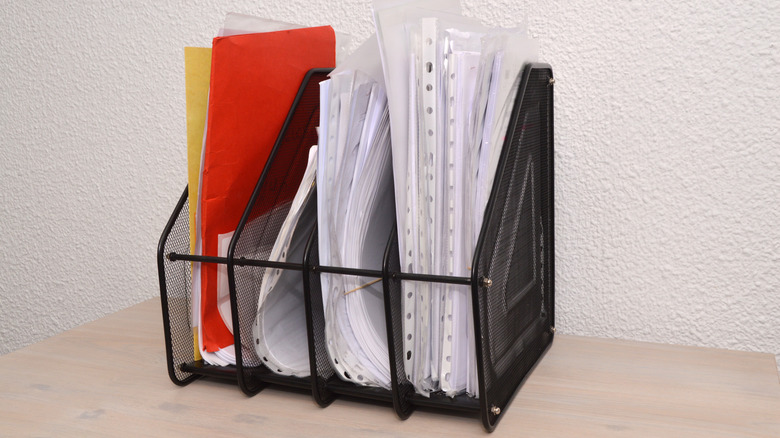 Papers stored in a vertical metal file holder