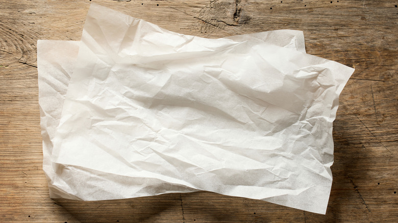 sheets of parchment paper stacked on wooden surface