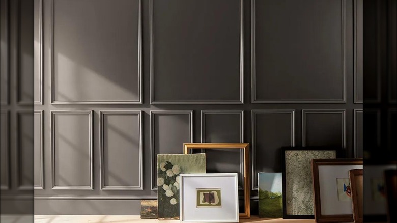 molding wall painted Benjamin Moore's 2026 Color of the Year, Silhouette, with artwork leaning against it