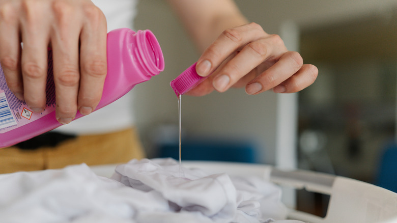 a person applies stain remover to fabric