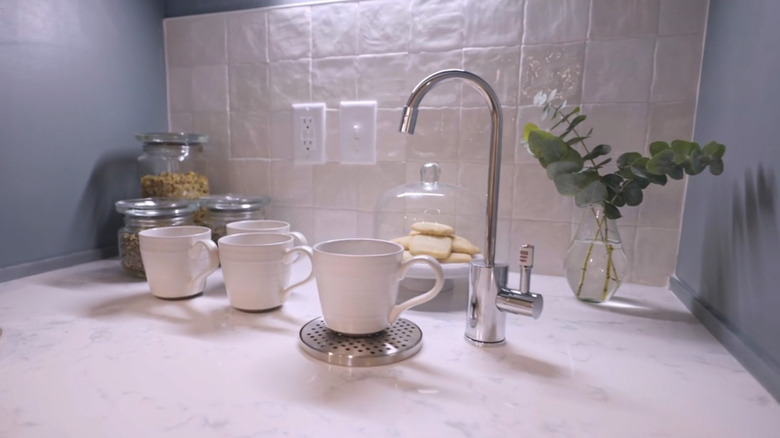 White square tile backsplash behind a countertop tea station