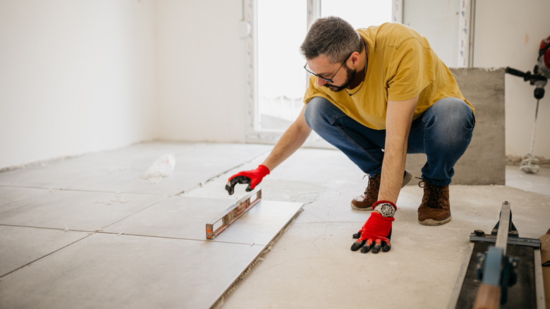 man installing tile flooring