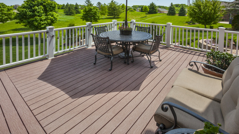 A brown deck made from PVC boards with a golf course in the background