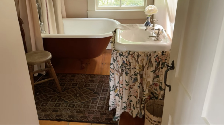 Cottage style bathroom with floral pedestal sink skirt