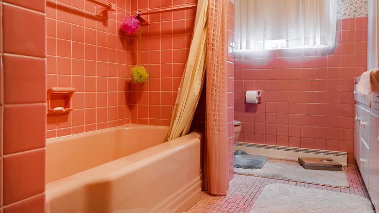 vintage bathroom with coral tile and light salmon colored built-in bathtub