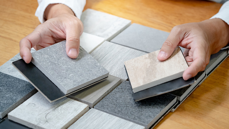 person choosing tiles from samples