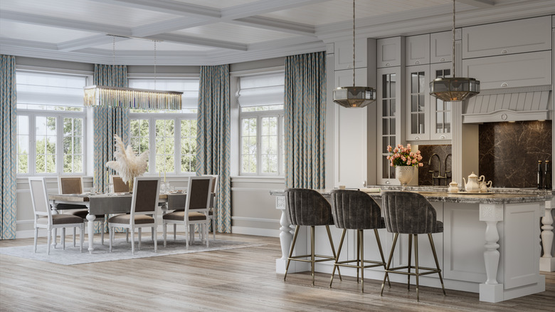 open concept living and dining areas with a large linear chandelier over the dining table and geometric smoked glass pendants over the island