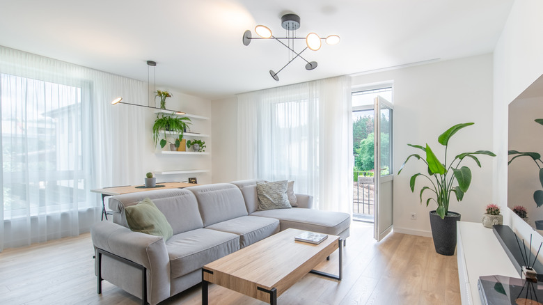 living room and dining room with matching chandelier and semi-flush mount black modern fixtures