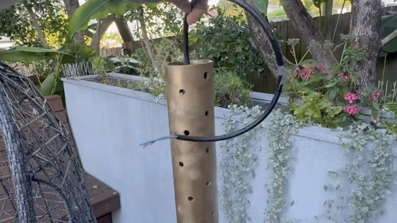 A DIY outdoor hanging light made out of PVC pipe painted gold