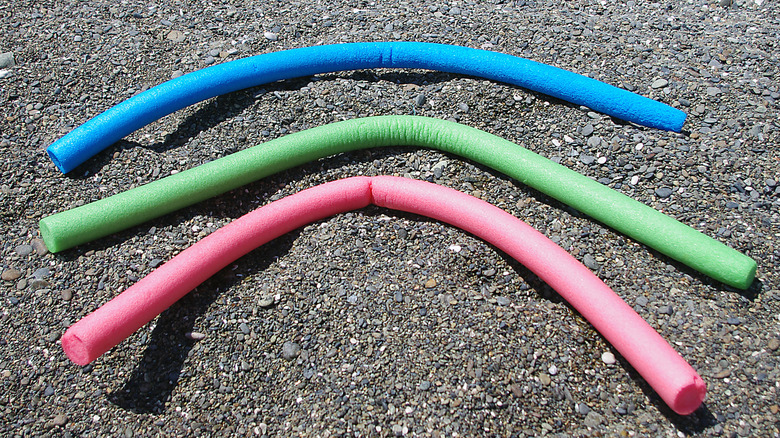 Colorful bent pool noodles lying outside