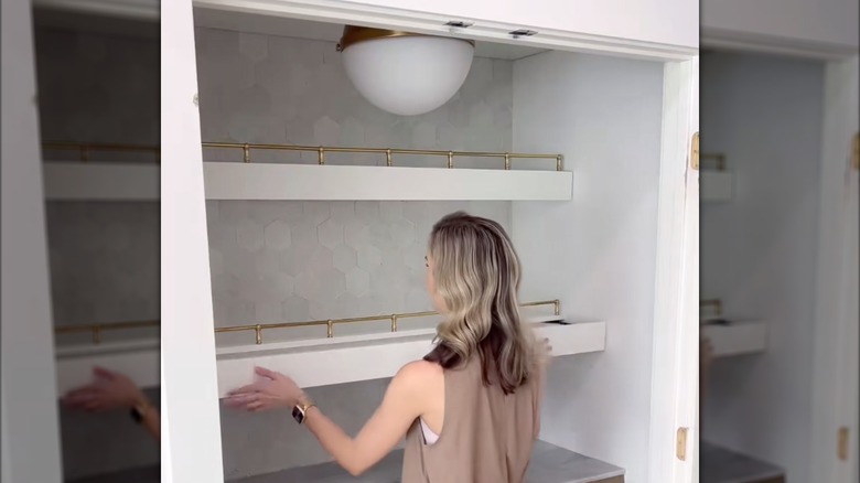 Woman closing drawer built into pantry floating shelves