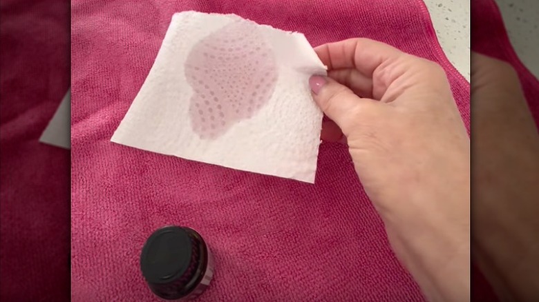 Person holding a paper towel soaked in essential oil