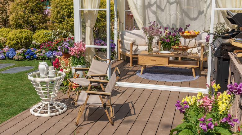 outdoor table and chair with grill, potted plants, and books