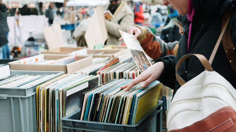A woman hunts through a box of records at the thrift store