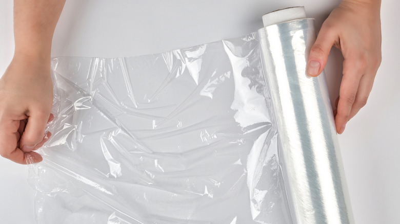 Person taking a section of plastic wrap