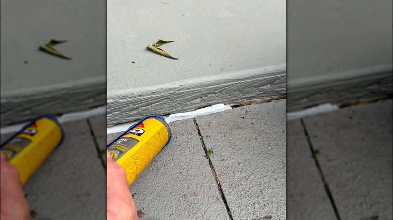 caulking gun applying caulk on a pool noodle in a cement crack