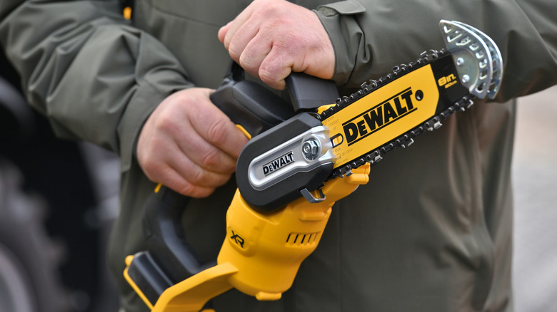 A construction worker holding a yellow DeWalt power tool