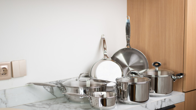 A collection of stainless steel cookware sitting on a countertop.