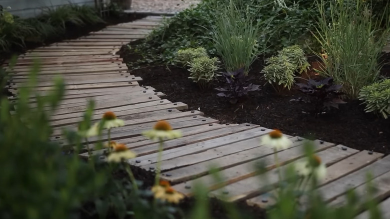 A wooden walkway through a garden
