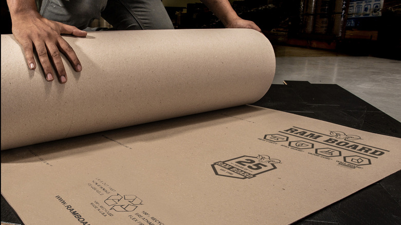 Worker rolling out ram board paper