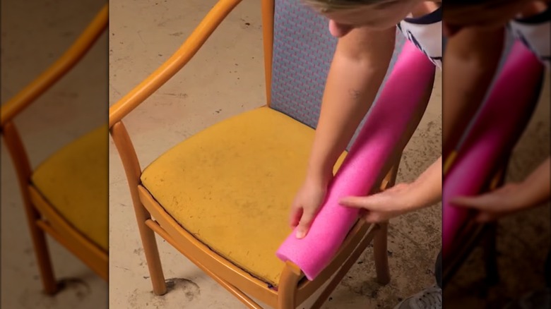 Woman wrapping the arm of a chair in pool noodle