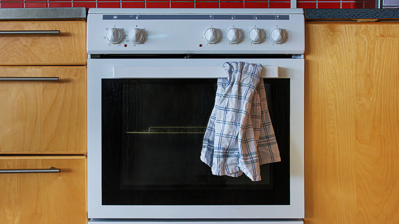 Kitchen towel hanging from oven