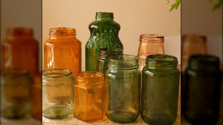 Assortment of transparent colored mason jars without lids on wood table
