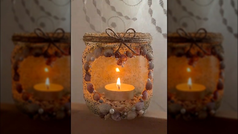 Beach-inspired tealight holder made from old jar and coastal accessories on tabletop