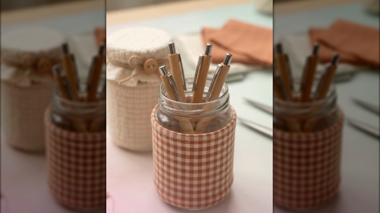 Repurposed glass jar wrapped with gingham fabric and filled with matching wood pens on clean table