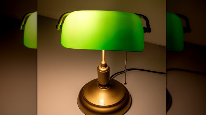 Classic bankers lamp with brass-colored base and green lampshade.