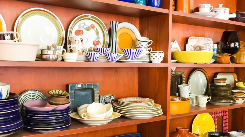 assorted kitchenware on a shelf in a thrift store