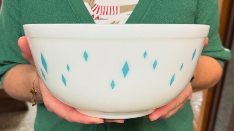 A person holds a Pyrex Dainty Maid Turquoise Diamonds bowl