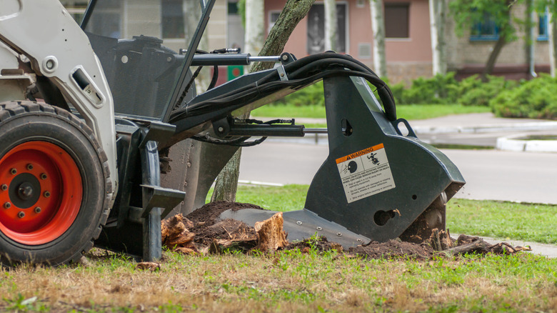 a machine grinding a stump away