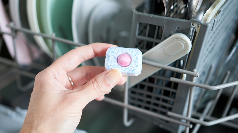 A detergent pod being added to a dishwasher