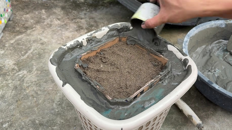 Pouring concrete mix into hamper