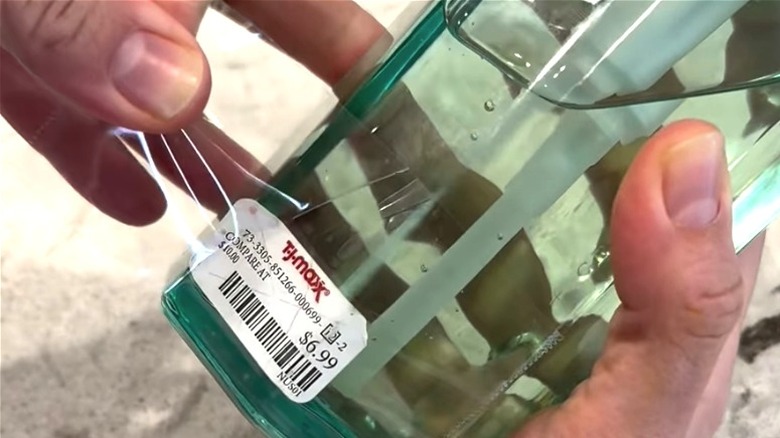 Person removing price tag sticker using packing tape and hair dryer