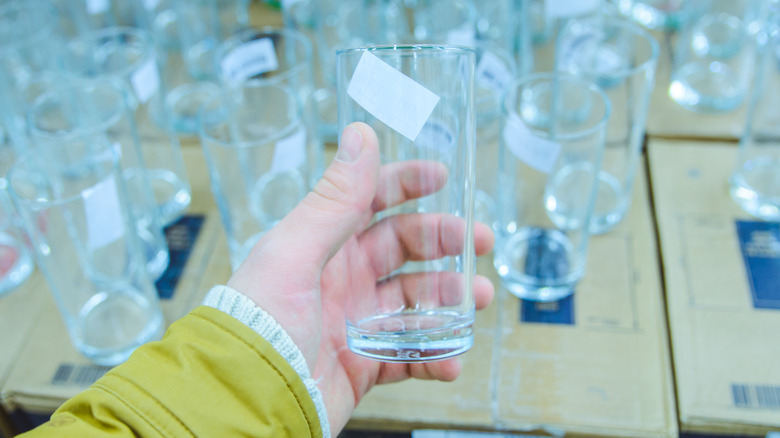 Man holding glass with price tag sticker on it