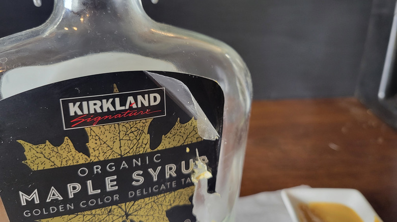 The protective plastic coating peeled away from a maple syrup bottle label