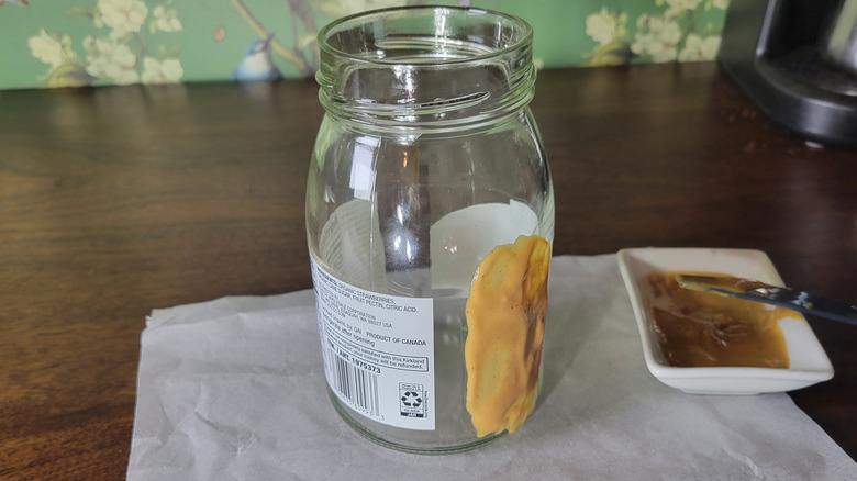 Peanut butter on part of a strawberry preserves jar label