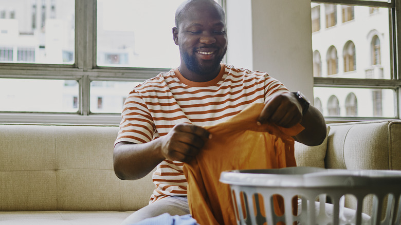 Smiling man looking at a clean shirt