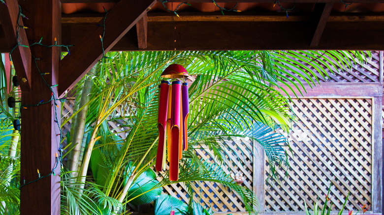 wind chimes hanging from wooden pergola