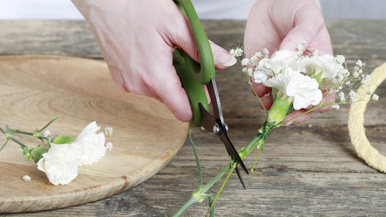 Female hands snipping small white flowers
